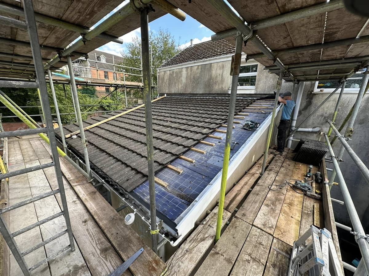 Before: extension under construction with roof tiles going on behind scaffolding, then the finished two-storey rendered extension with French doors